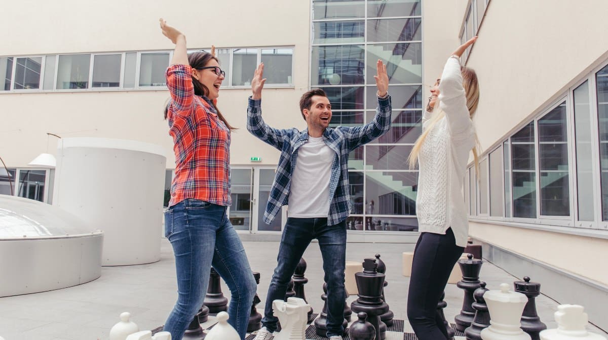 Comment les jeux d’échecs ont réussi à séduire la Gen Z et à devenir un sport tendance 1 Jeunes adultes jouant à un jeu d'échecs maxi format